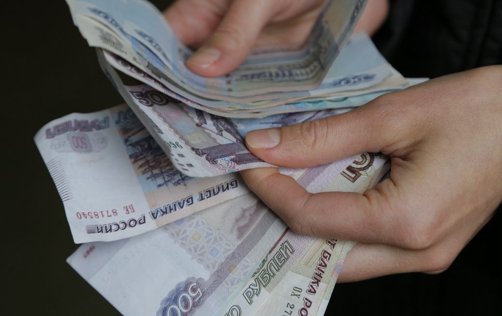 A vendor counts Russian rouble banknotes at a market in Moscow, March 3, 2014. Russian assets tumbled and the central bank hiked interest rates on Monday as markets took fright at the escalating tensions with neighbouring Ukraine. The rouble was down 2 percent to 36.41 against the dollar and it was also down 1.2 percent to 50.10 against the euro, trading at all-time lows. REUTERS/Maxim Shemetov (RUSSIA - Tags: BUSINESS)